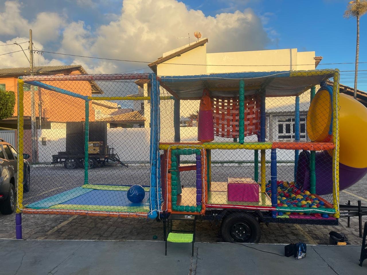 Vista lateral da carretinha PlayKids com piscina de bolinhas e circuito de obstáculos